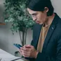 Un jeune homme au bureau, consultant son téléphone